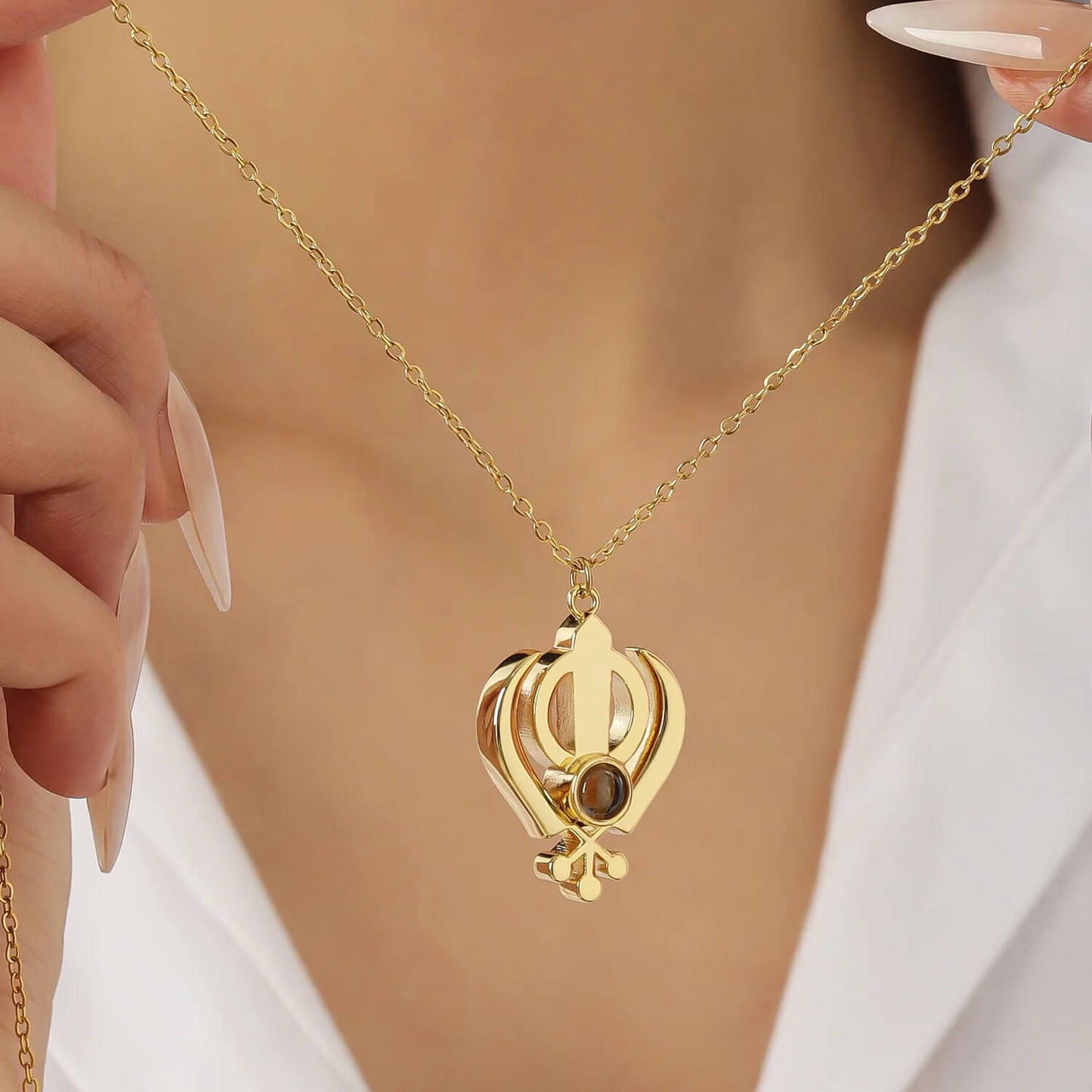 Model holding gold 3D Khanda Pendant Necklace, showcasing its elegant design and customizable projection feature.