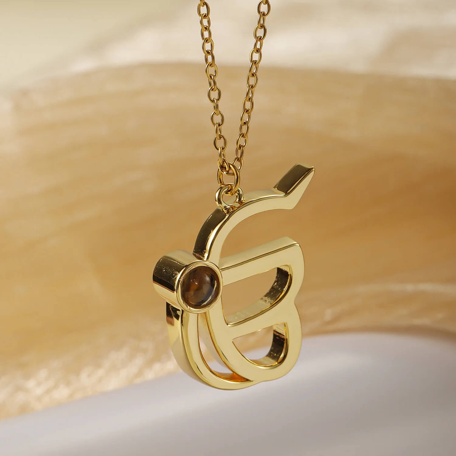 Angled view of gold 3D Punjabi Projection Necklace pendant, showcasing its 3D structure and photo projection lens.