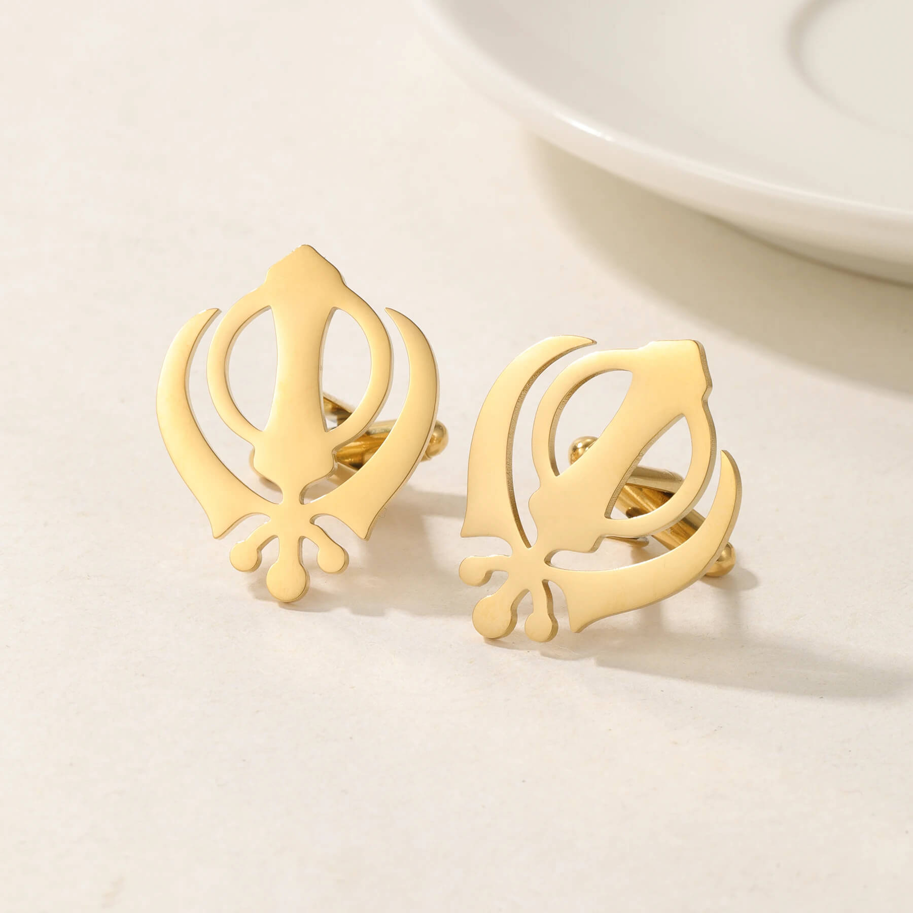 18K gold Punjabi Sikh cufflinks with Khanda symbol, displayed on a white surface for elegant men's accessory appeal.