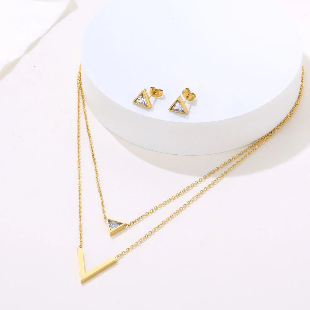 Velora V Set jewelry featuring geometric gold pendant necklace and matching triangle earrings on display.