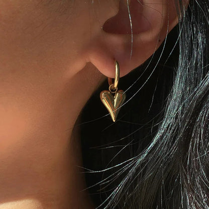 Close-up of Chic Heart Hoop Earrings in 18K Gold PVD plating, showcasing a heart-shaped pendant on polished hoop.