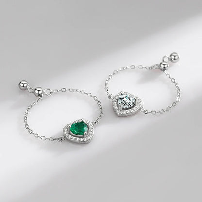 Elegant heart-link chain rings in sterling silver with green and clear cubic zirconia stones, perfect for self-expression.