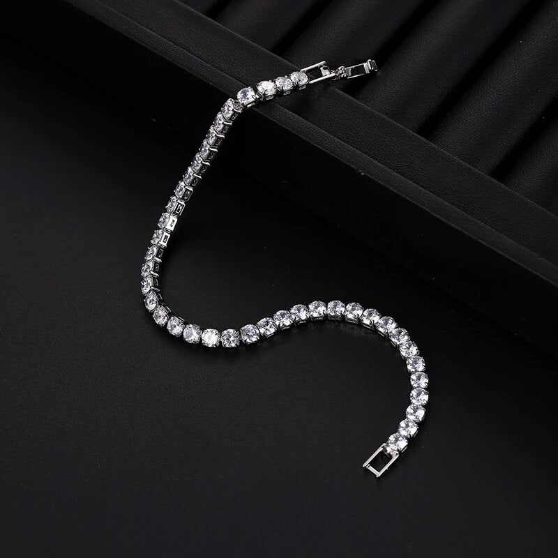Unclasped silver iced out tennis bracelet with clear zirconia stones, showcasing flexibility and shine for hip hop fashion.