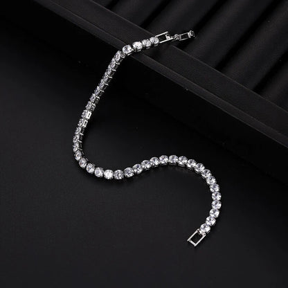 Unclasped silver iced out tennis bracelet with clear zirconia stones, showcasing flexibility and shine for hip hop fashion.