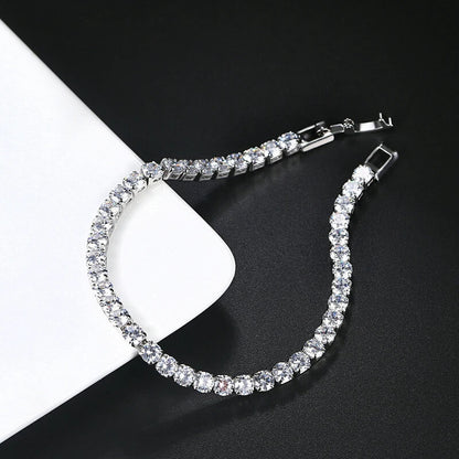 Open silver iced out tennis bracelet with clear zirconia on black and white background, modern hip hop jewelry design.