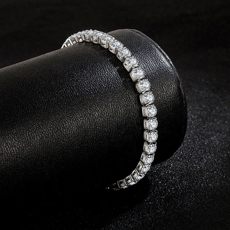 Silver iced out tennis bracelet wrapped around a black display roll, highlighting cubic zirconia brilliance for hip hop style.
