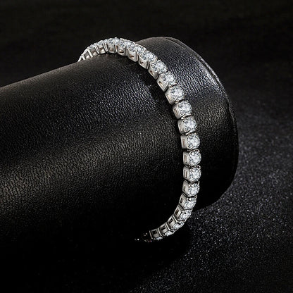 Silver iced out tennis bracelet wrapped around a black display roll, highlighting cubic zirconia brilliance for hip hop style.